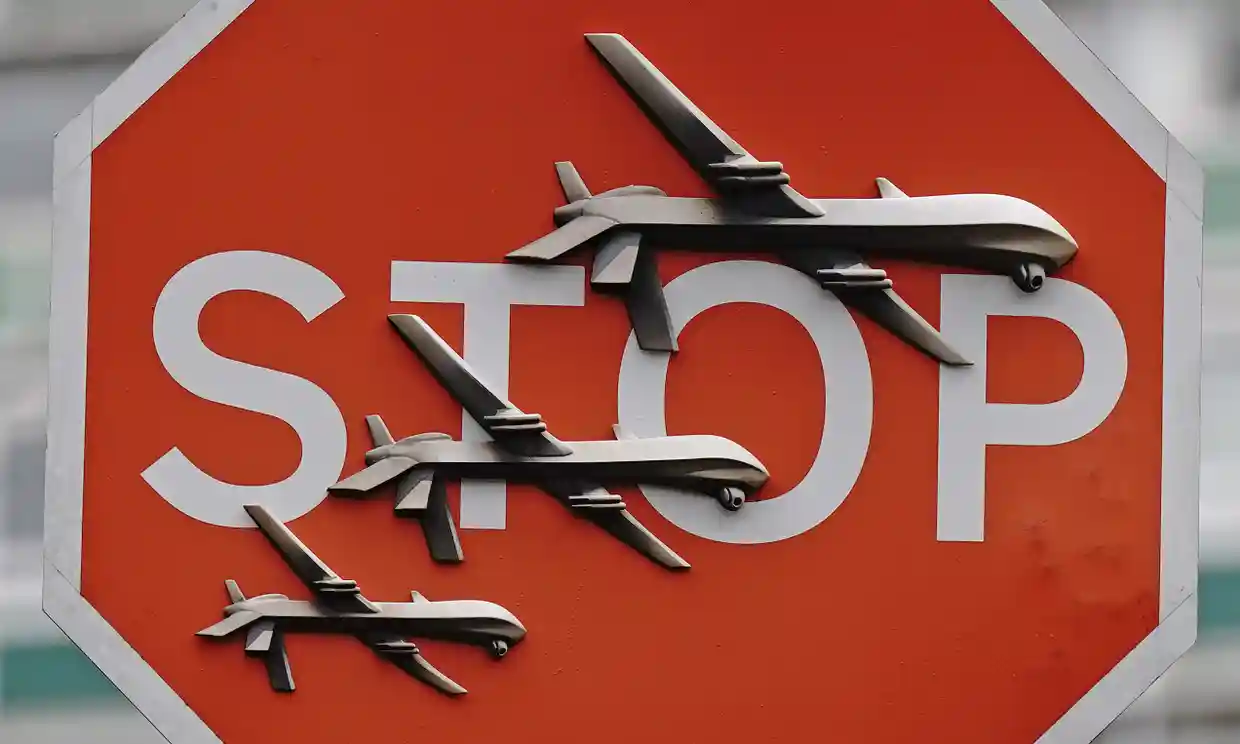 An image of a red stop sign with three silver drones stuck on top of it.